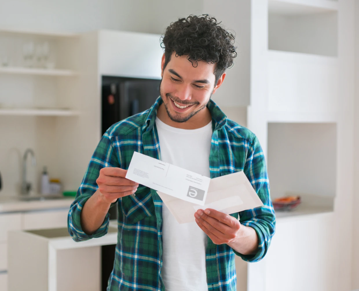 Man reading a letter in the kitchen